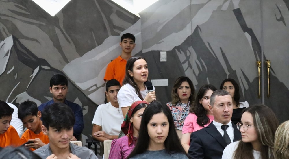 a woman participant of the event speaking to the microphone