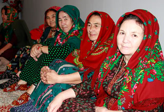 Elderly women in traditional Turkmen clothes sitting in the room