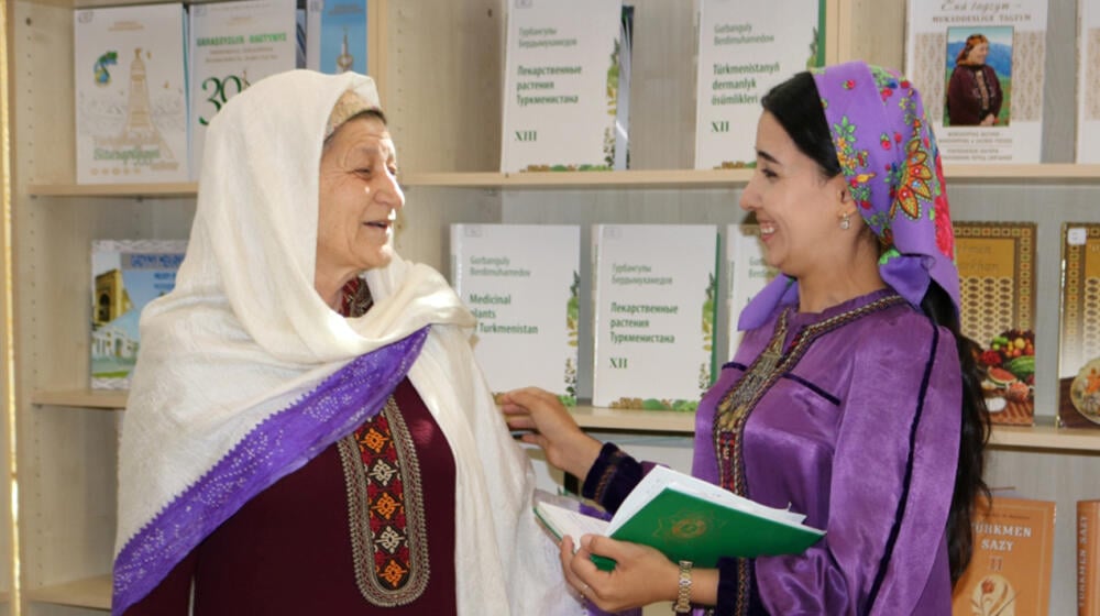 Young girl laughing and speaking with older woman librarian