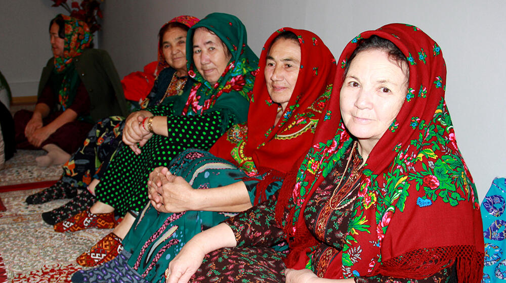 Elderly women in traditional Turkmen clothes sitting in the room