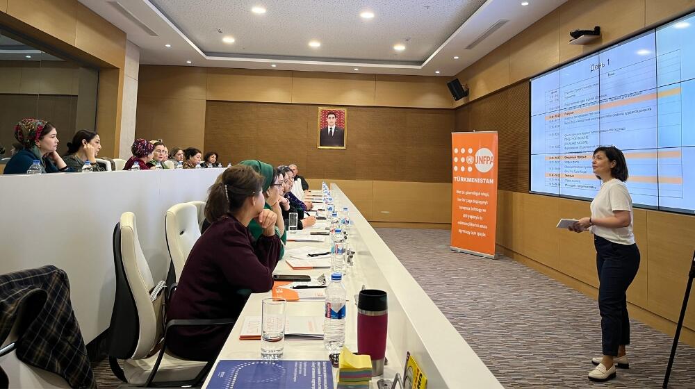 a person presenting in fron the people in the conference hall