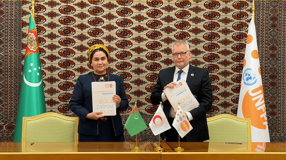 Two people are standing and holding folders